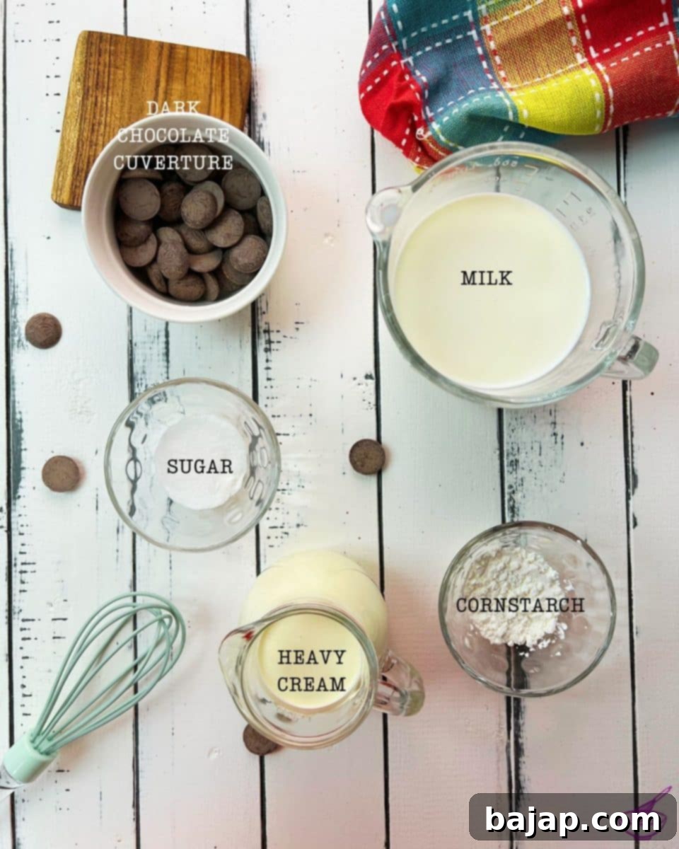Five simple yet high-quality ingredients – dark chocolate couverture, whole milk, granulated sugar, cornstarch, and heavy cream – neatly arranged to showcase what's required for a scrumptious homemade dark chocolate pudding.