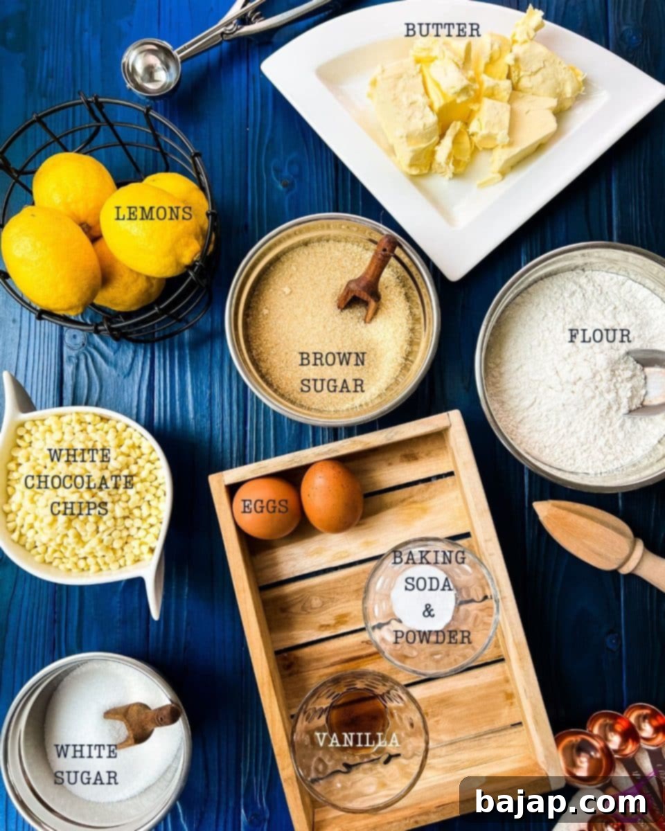 A flat lay of all the fresh ingredients needed for making delicious lemon white chocolate chip cookies, including butter, flour, sugars, eggs, lemon, and white chocolate chips.