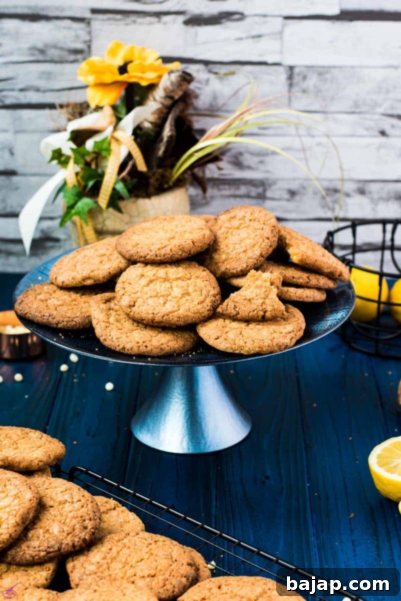 A beautiful display of lemon white chocolate chip cookies on a blue cake stand, ready to be enjoyed with a spritz.