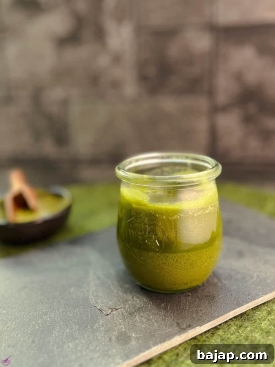 Effortless Matcha Butter Recipe 2 A preserving jar filled with vibrant green Matcha butter (after cooling) on a rustic slate plate, ready for use in baking.