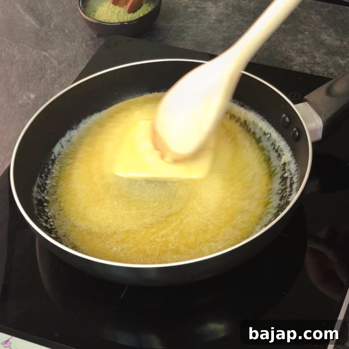 Effortless Matcha Butter Recipe 4 A small frying pan on a stove with unsalted butter beginning to melt, initiating the matcha butter making process.