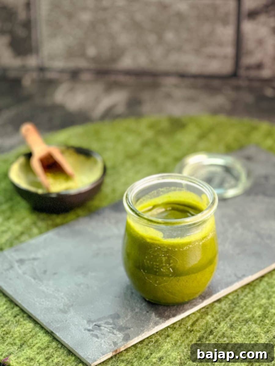 Effortless Matcha Butter Recipe 9 A preserving jar filled with firm, vibrant green Matcha butter (after cooling) on a slate plate, ready for spreading.