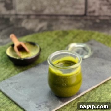 Effortless Matcha Butter Recipe 10 A preserving jar filled with vibrant green Matcha butter (after cooling) on a slate plate, showcasing its rich texture.