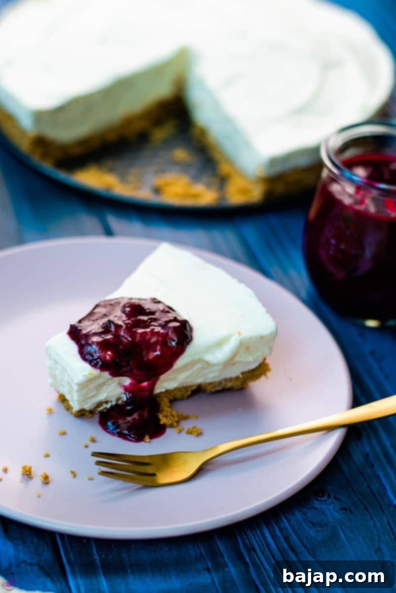 Refreshing lemon cheesecake slice with blueberry sauce on dark blue wooden background.
