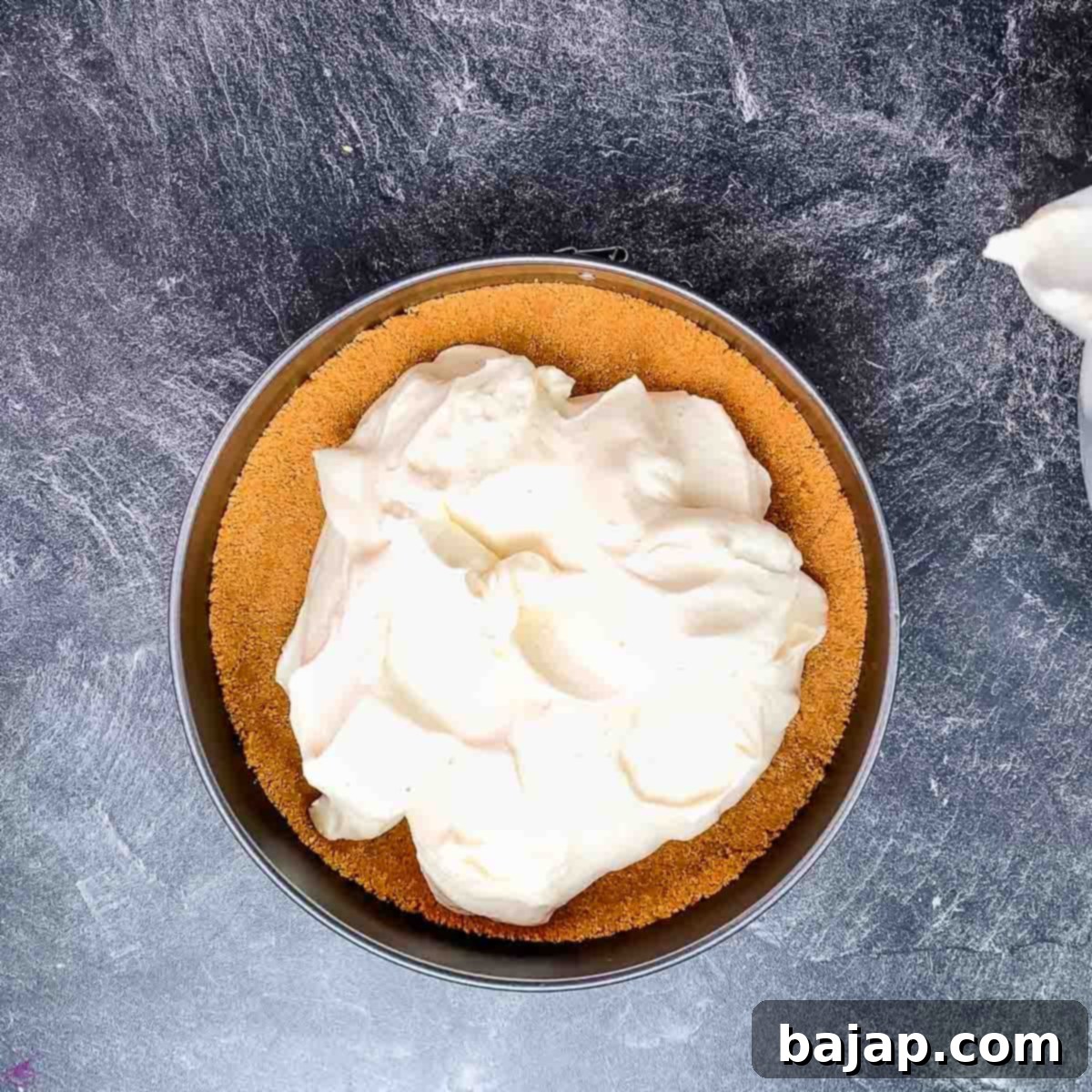 Spread the lemon cheesecake filling on top of the graham cracker crust.