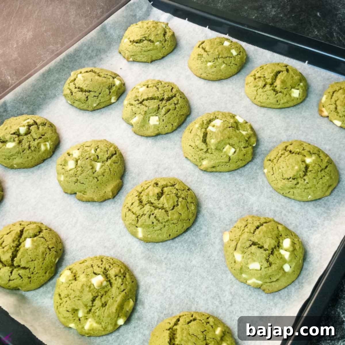 Matcha cookies after baking on the baking sheet, golden brown at the edges and perfectly set.