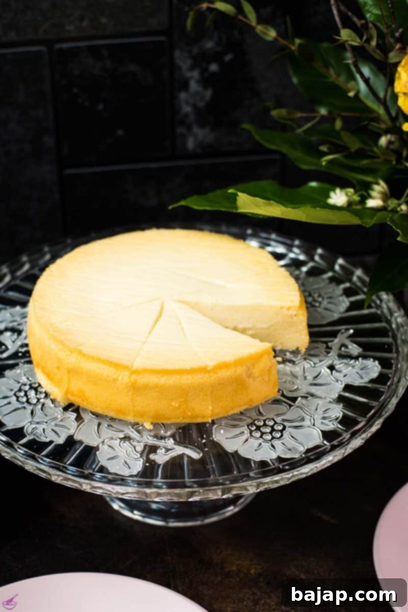 Golden-brown three-ingredient yogurt cake on a beautiful glass cake plate, ready to be served.