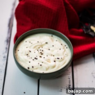 Gorgeous green bowl on white wooden board filled with delicious white chocolate pudding.