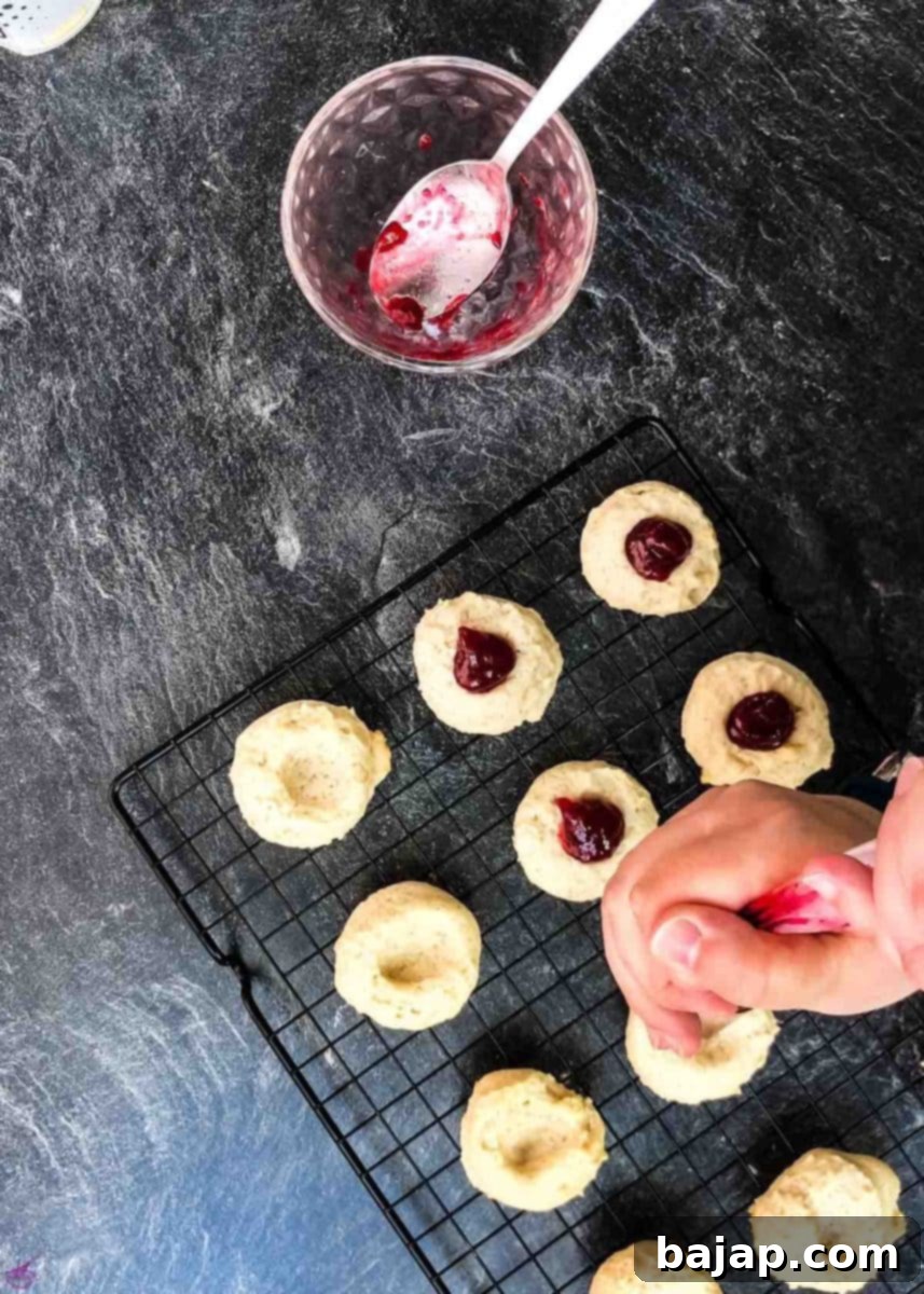 Pipe the raspberry jam onto the cookies.