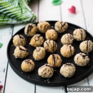Gorgeous mascarpone eggnog cookie, rolled in ladyfinger crumbs and drizzled with chocolate sauce. Placed on black serving plate.