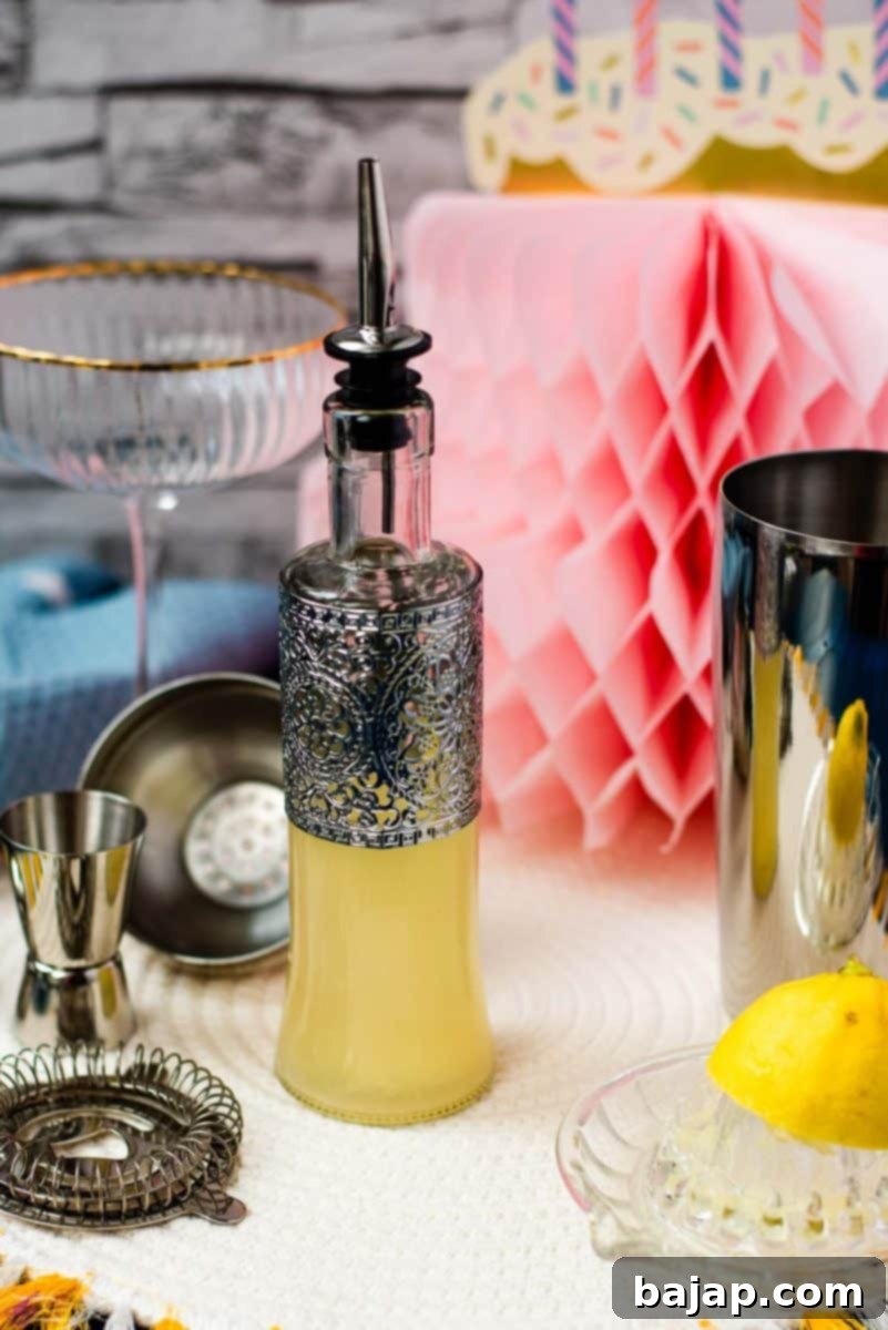 Bottle filled with freshly squeezed lemon juice fitted with a pouring spout, surrounded by cocktail making tools.