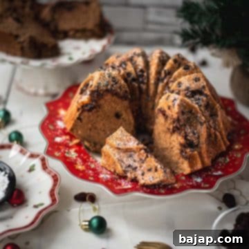 Gorgeous cranberry bundt cake with chocolate chips, cinnamon, and of course dried cranberries. Placed on a red plate.