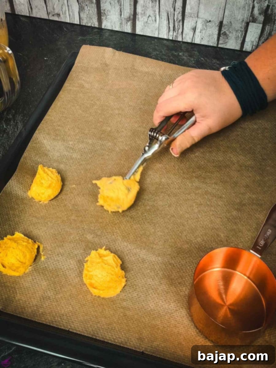 Taste Autumn's Warmth: Unbelievably Soft Pumpkin Cookies 11 Scoop the pumpkin cookie dough onto a baking sheet lined with parchment paper.