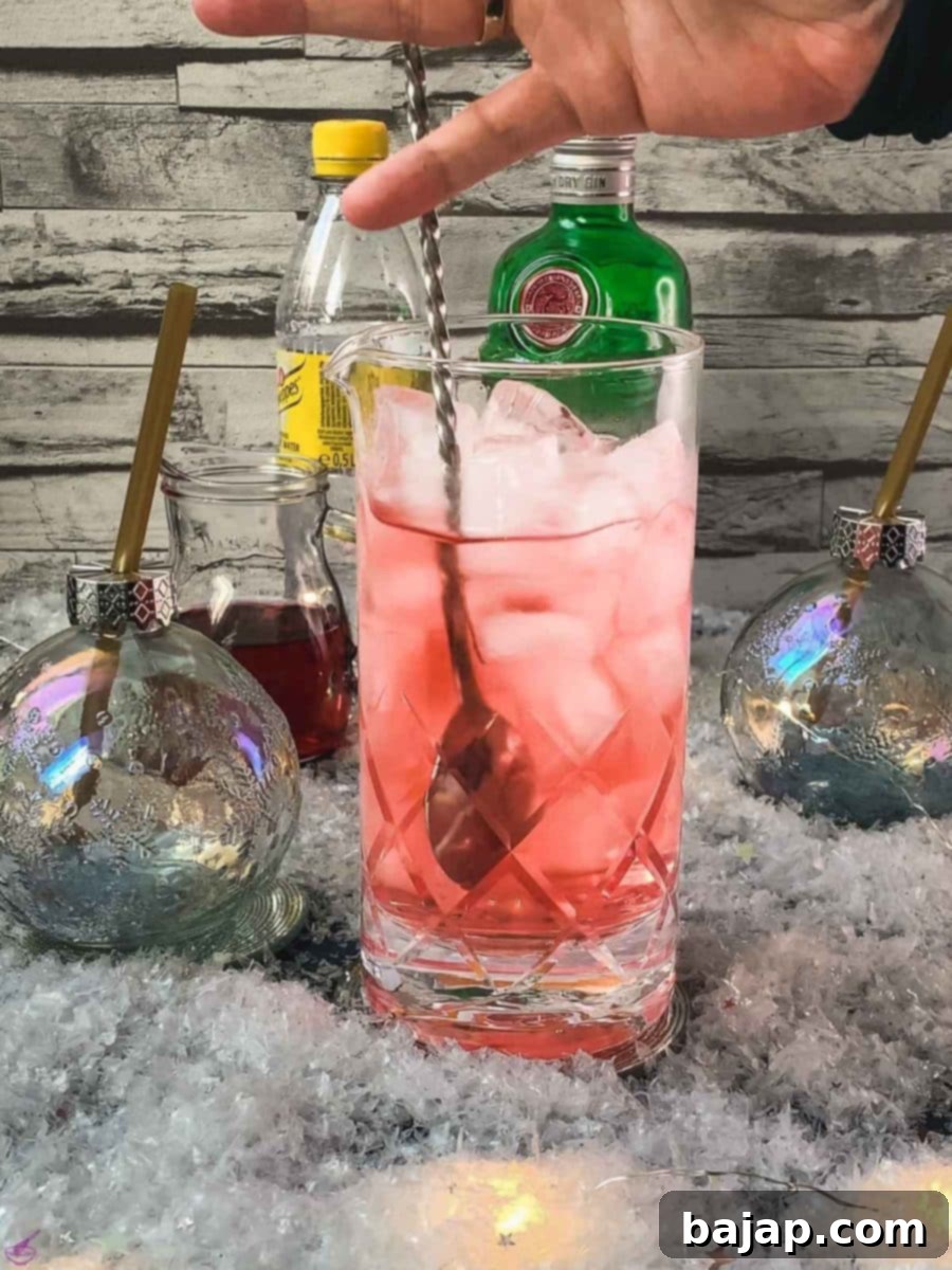 Gently stir the cranberry gin and tonic mixture to combine all ingredients.