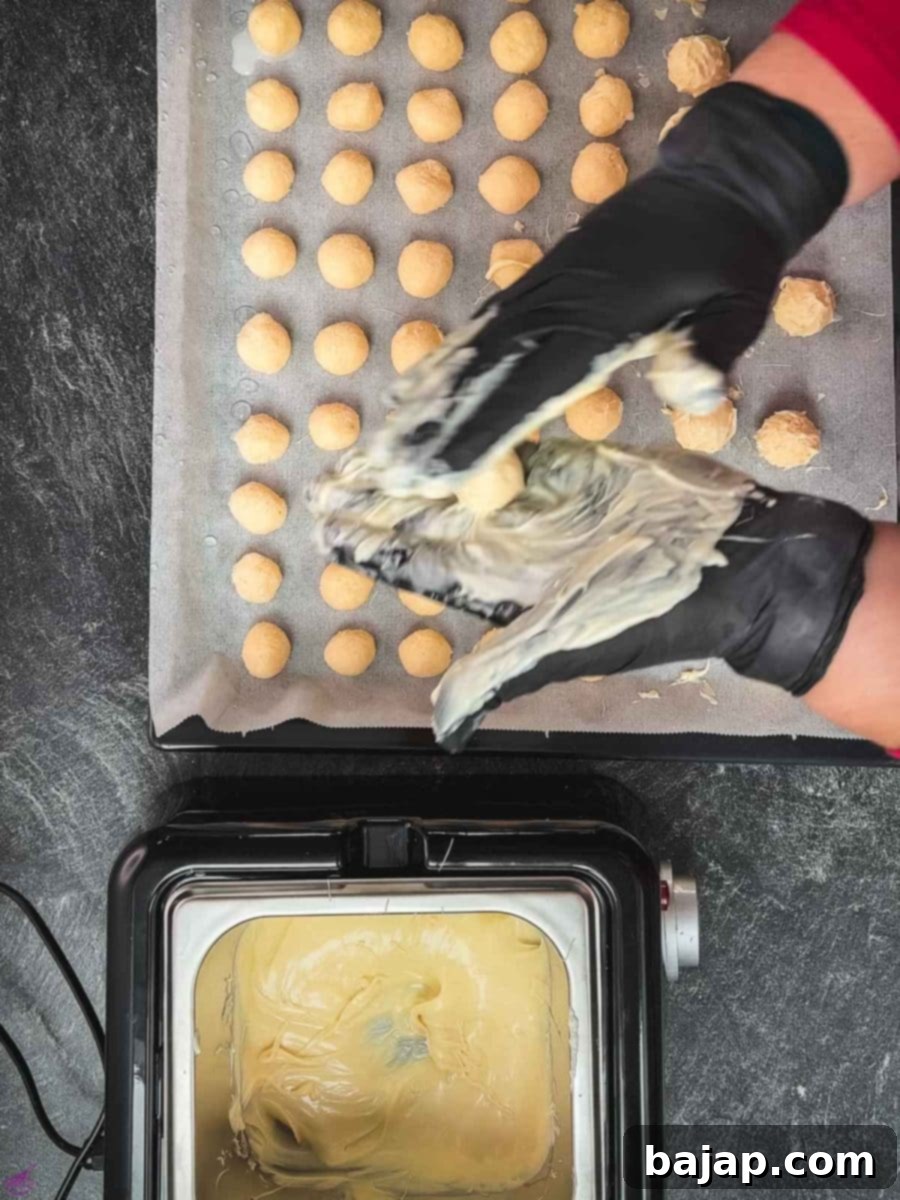 Roll the coconut balls between your white chocolate-covered hands.