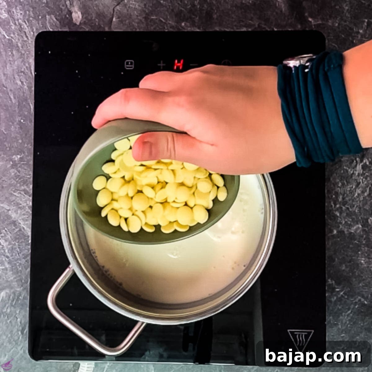 Add the white chocolate chips (couverture) to the milk in the saucepan, ready to melt and combine.