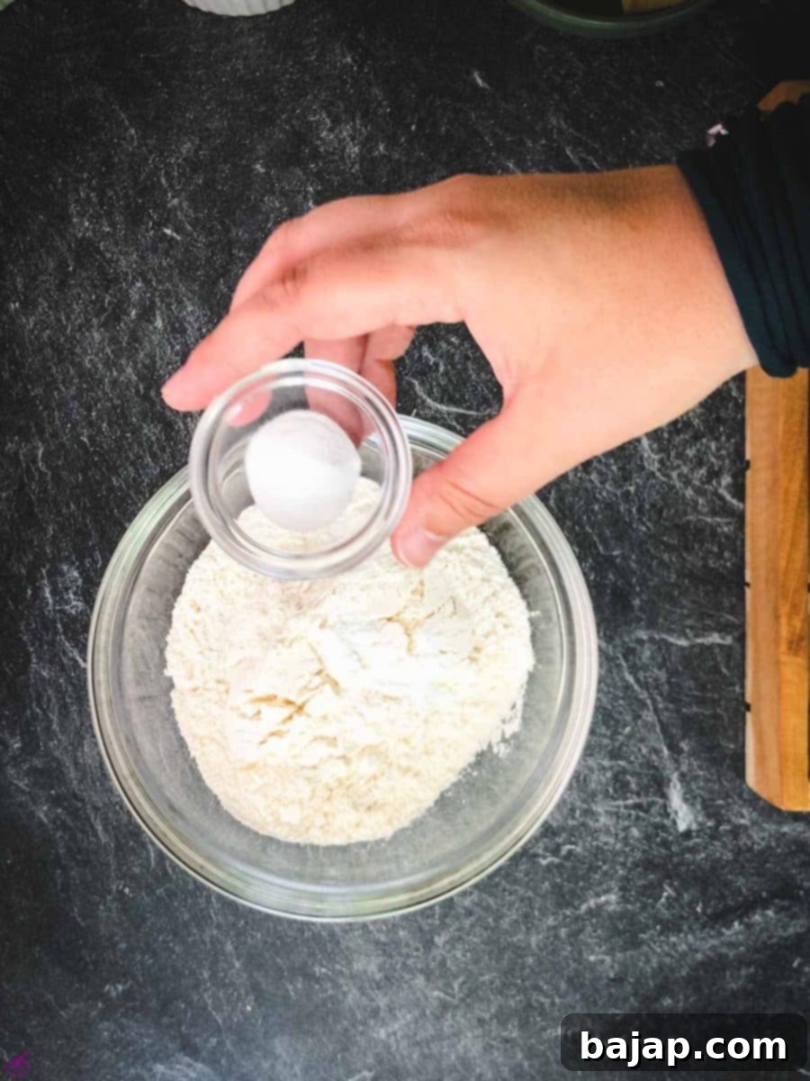 Mixing dry ingredients like flour, baking soda, baking powder, and salt in a separate bowl.