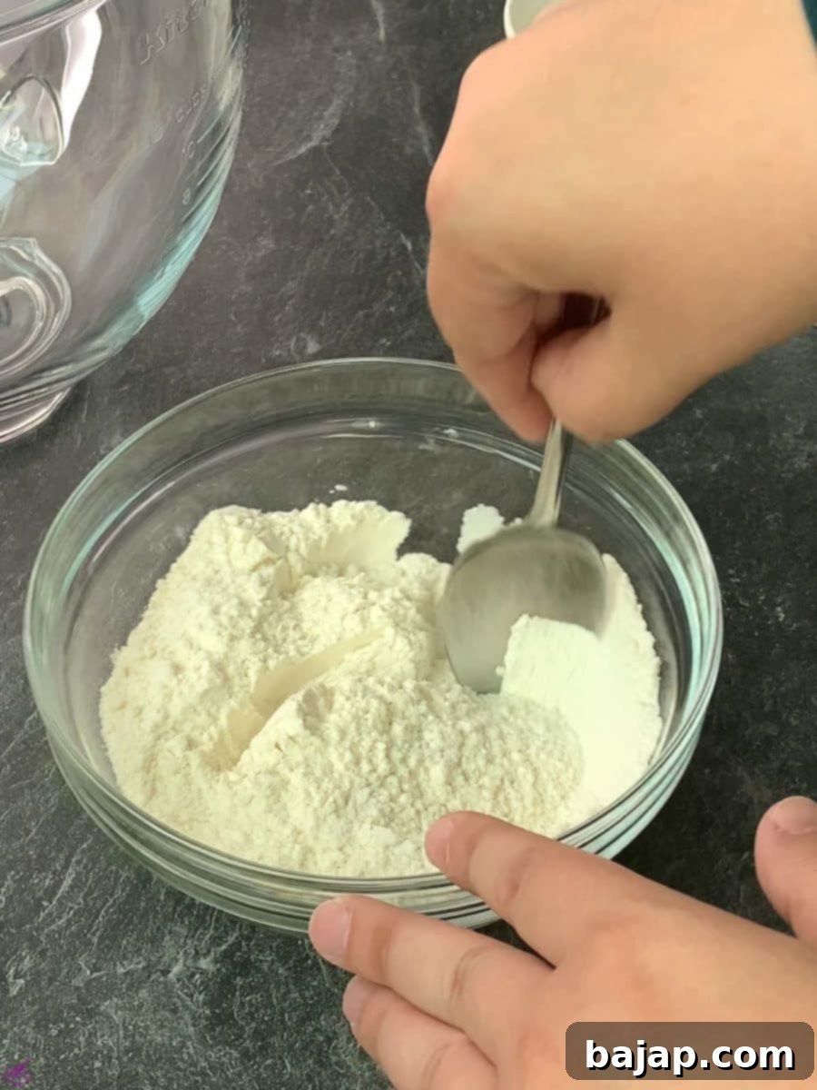 Adding the dry flour mixture to the wet cookie dough ingredients.