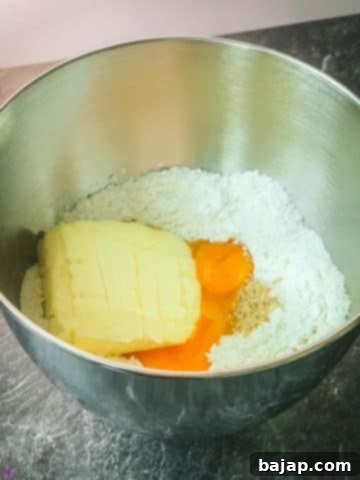 Make a dent in the center and add the remaining ingredients in order (powdered sugar, vanilla sugar, grated hazelnuts, yolks, butter in pieces).