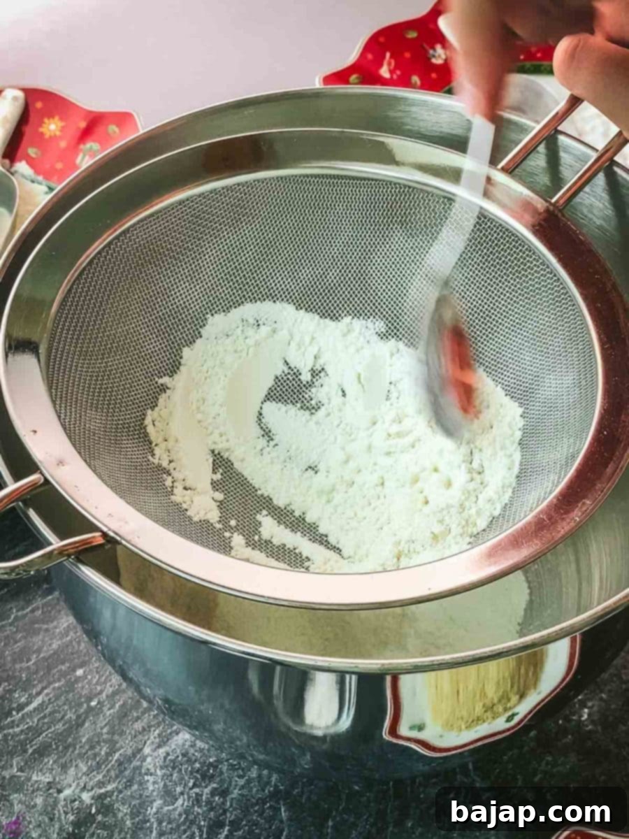 Sifting cake flour and baking powder into a mixing bowl to ensure even distribution and a light cookie texture.