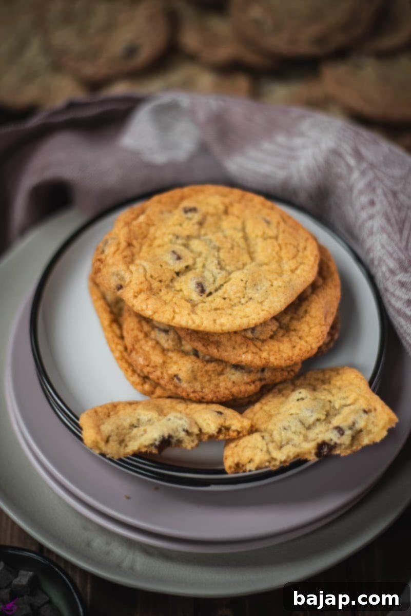 A vibrant display of delicious rum chocolate chip cookies arranged on various colorful and uniquely sized plates.