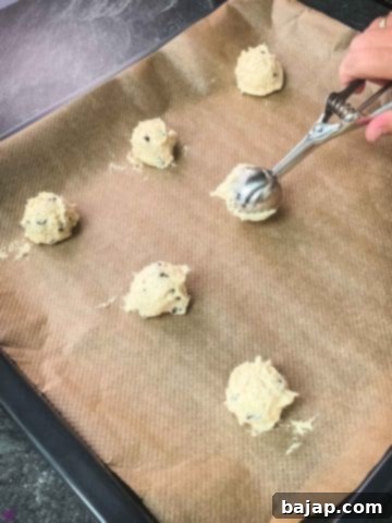 Scoop the dough into balls and evenly space them on a lined baking sheet.