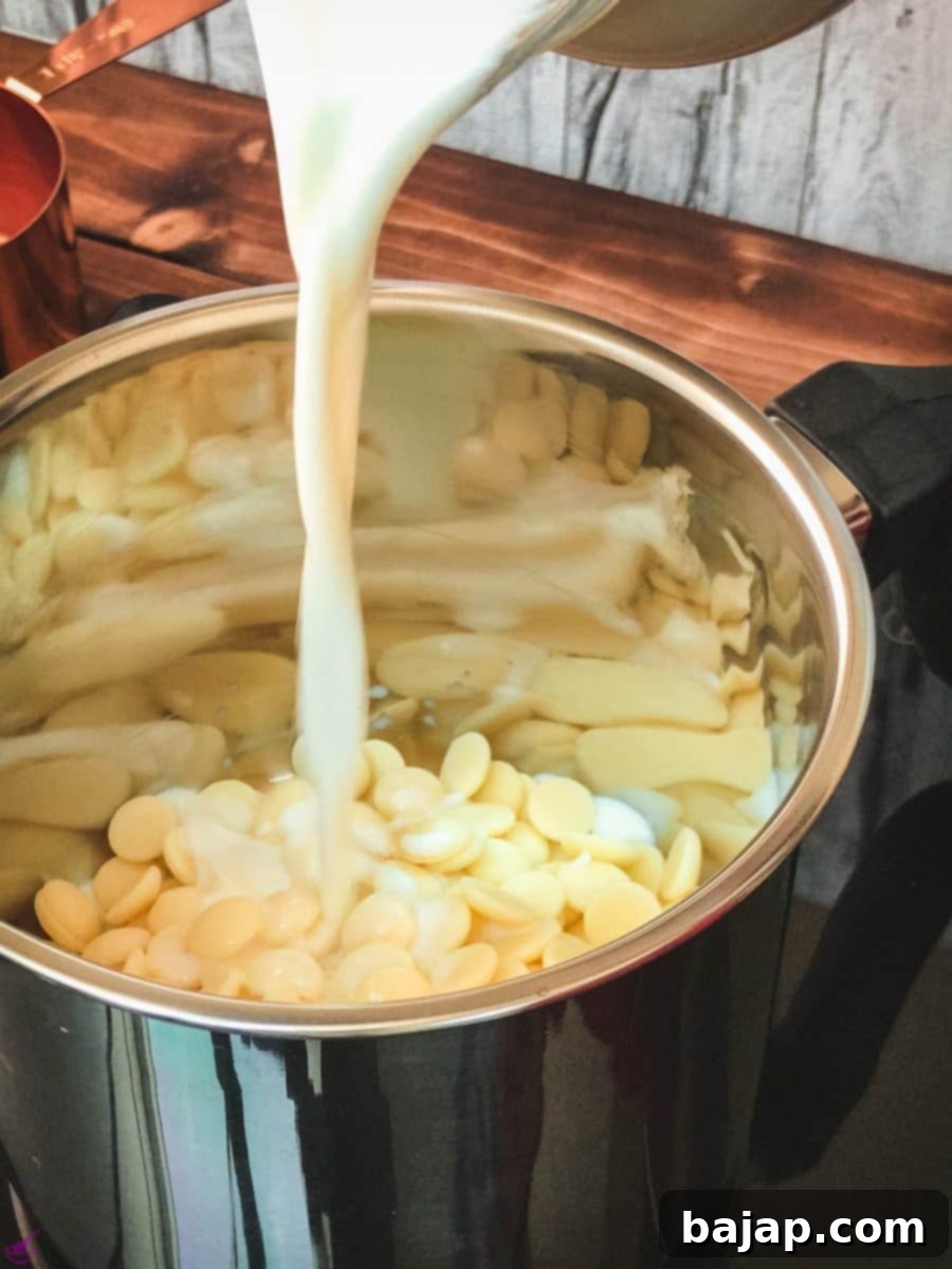 Pouring whole milk into a small saucepan, ready to be combined with white chocolate chips and vanilla extract for homemade hot chocolate.
