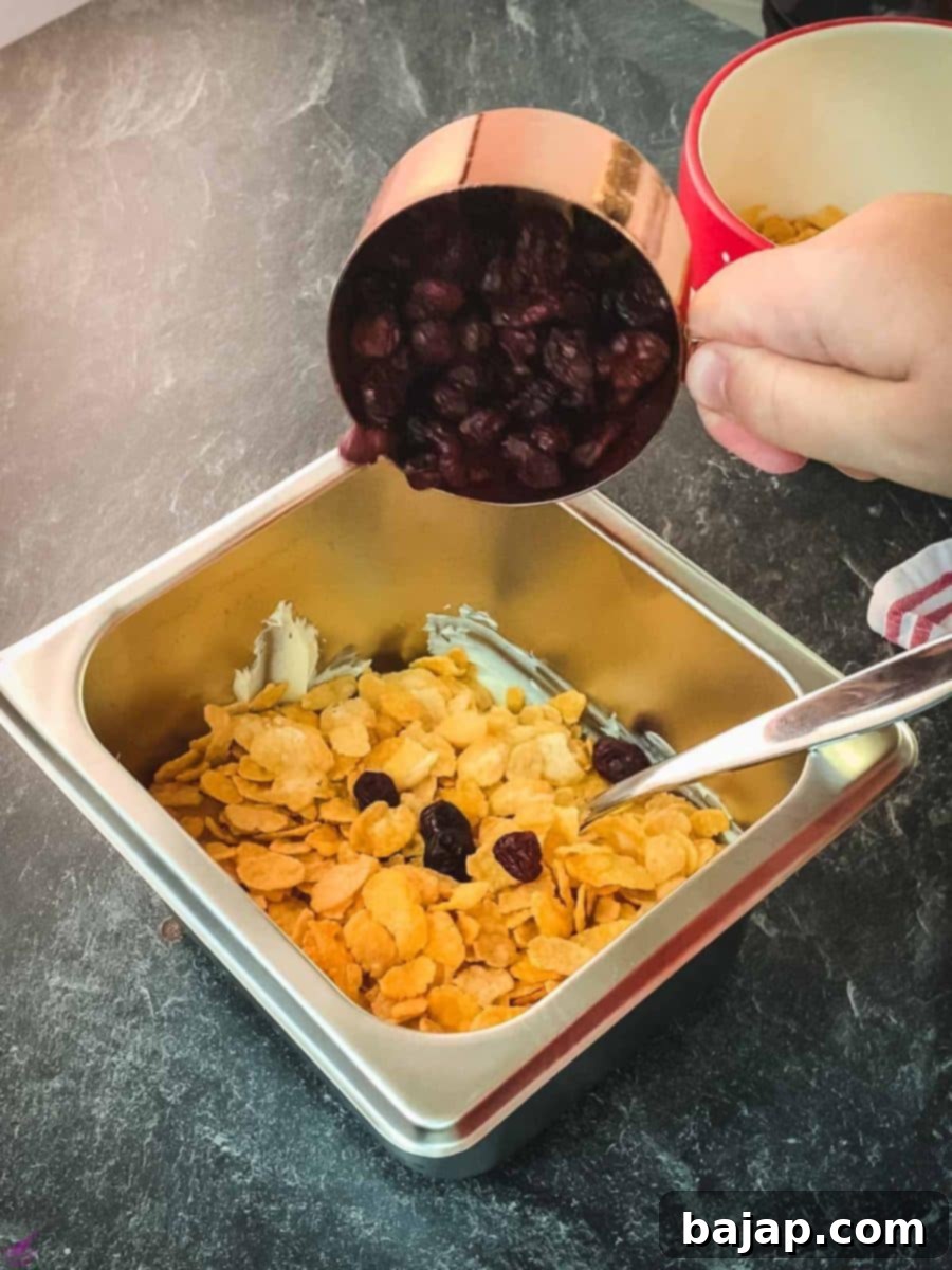 Add the tart dried cranberries to the white chocolate and cornflake mixture to introduce a delightful fruity flavor and chewy texture.