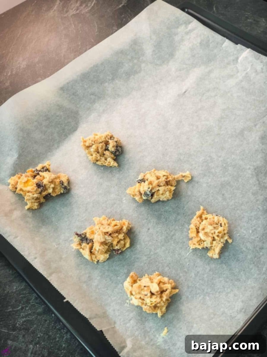 Portion the white chocolate cranberry cornflake mixture using a tablespoon onto a lined baking sheet and let them set until firm.