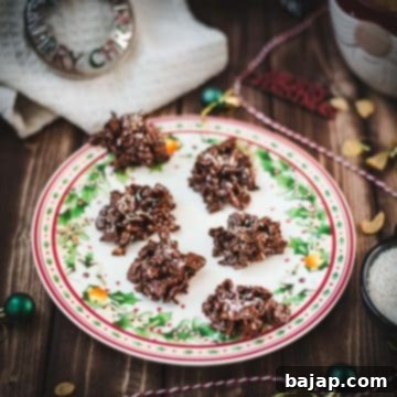 Christmas plate filled with dark chocolate clusters, on brown wooden background, next to Christmas decorations.