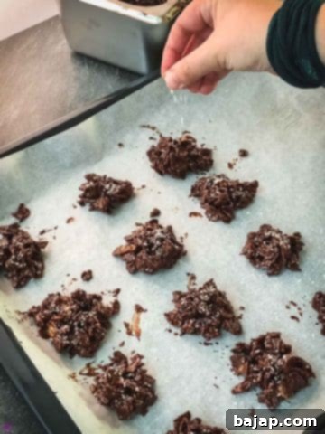 Sprinkle the cornflake clusters immediately with desiccated coconut.