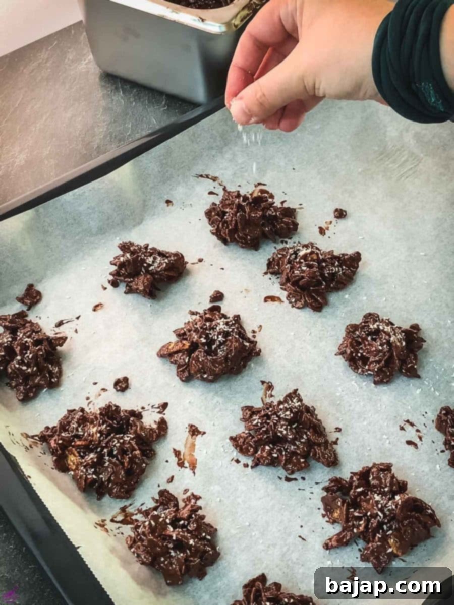 Sprinkle the cornflake clusters immediately with desiccated coconut.