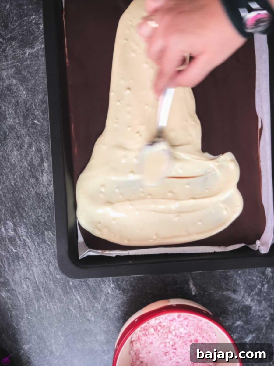 Spread the melted white chocolate on top of the firm dark chocolate layer.