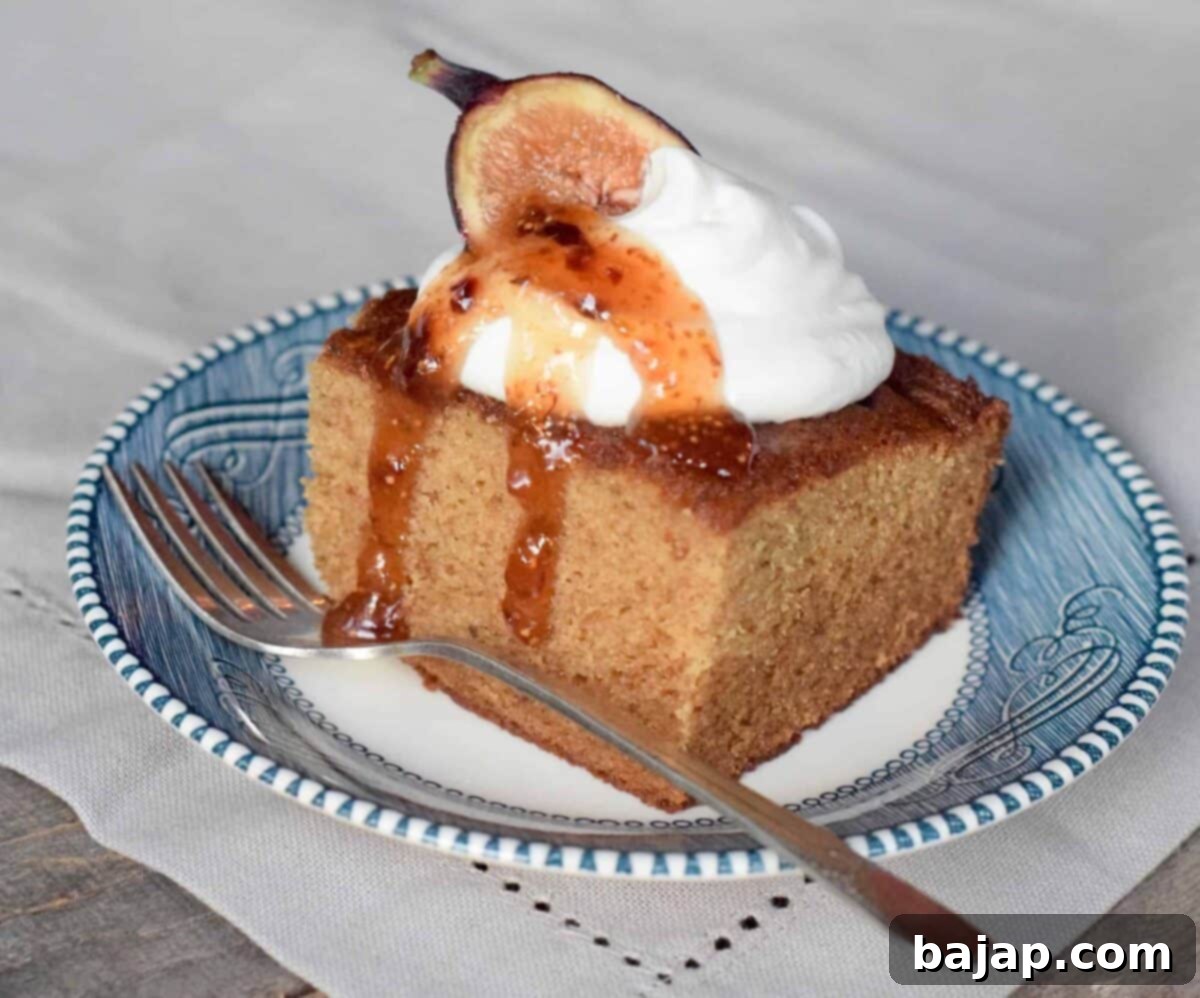 A delectable slice of fig jam cake, moist and tender, with visible fruit pieces, presented on a plate ready to be enjoyed as a comforting snack.