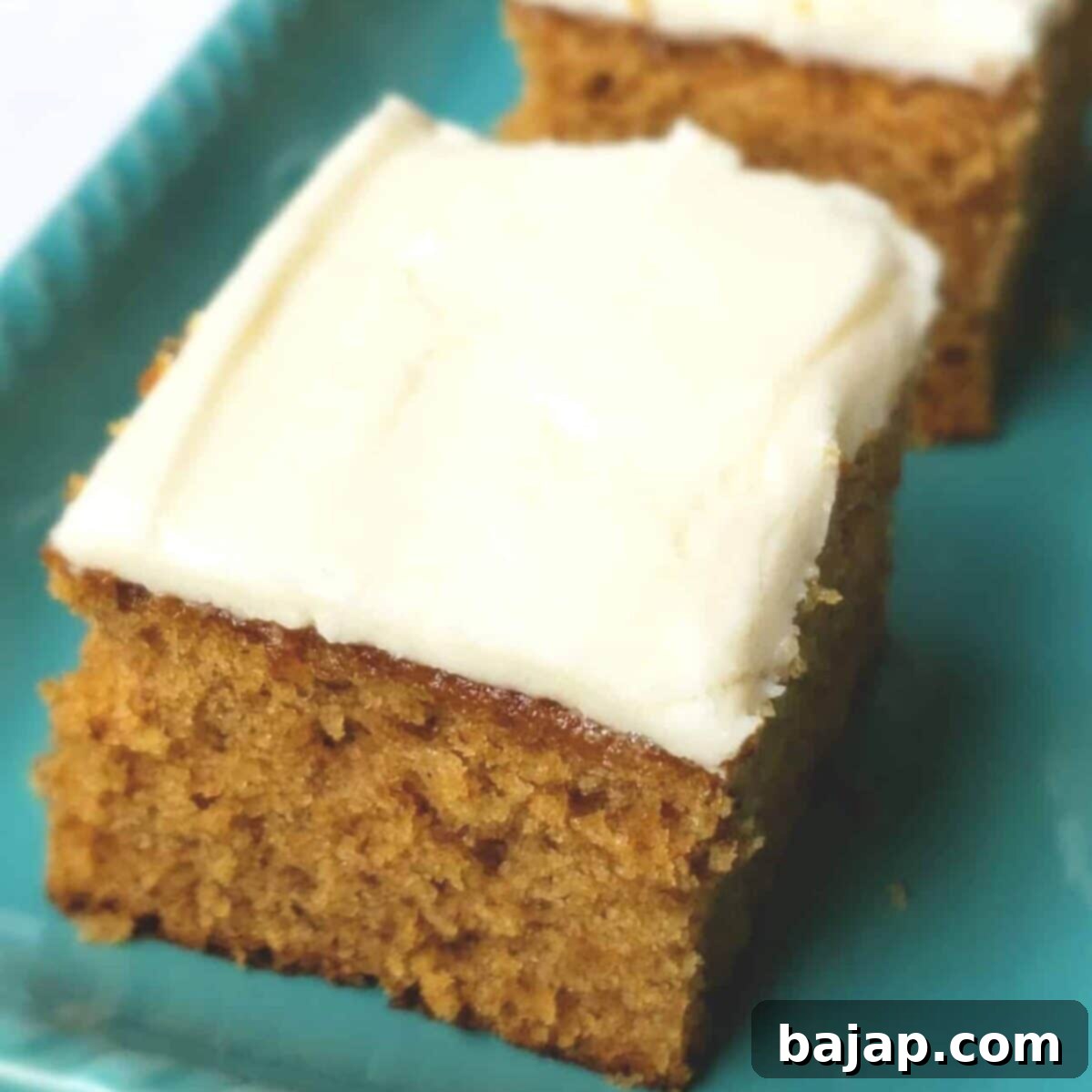 A generously frosted fig jam cake with maple buttercream, showcasing a rich, moist texture and inviting appeal. The frosting is smooth and perfectly piped.