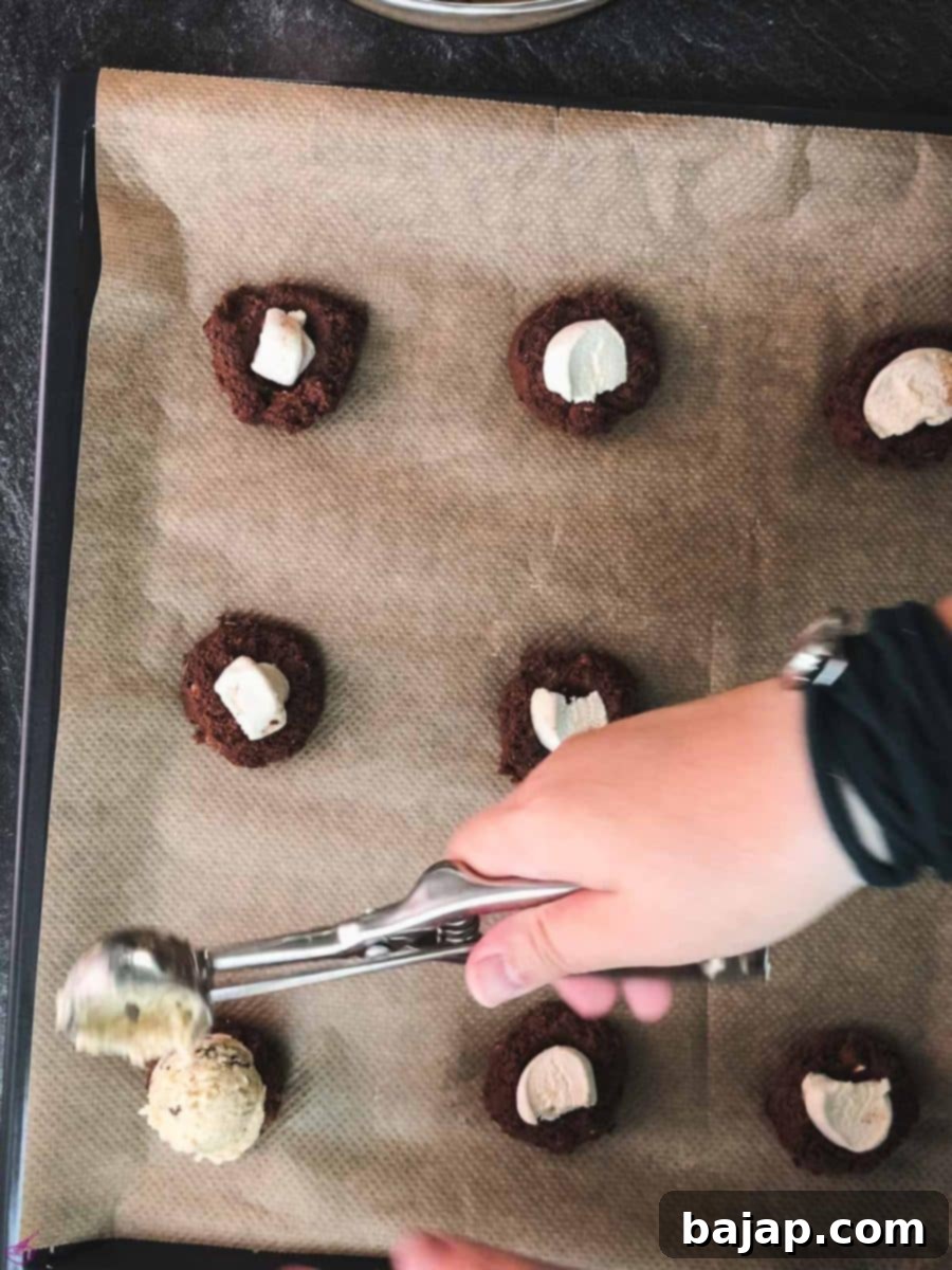 Scoop the vanilla cookie dough on top of the dark cookie dough with the marshmallow in the center.