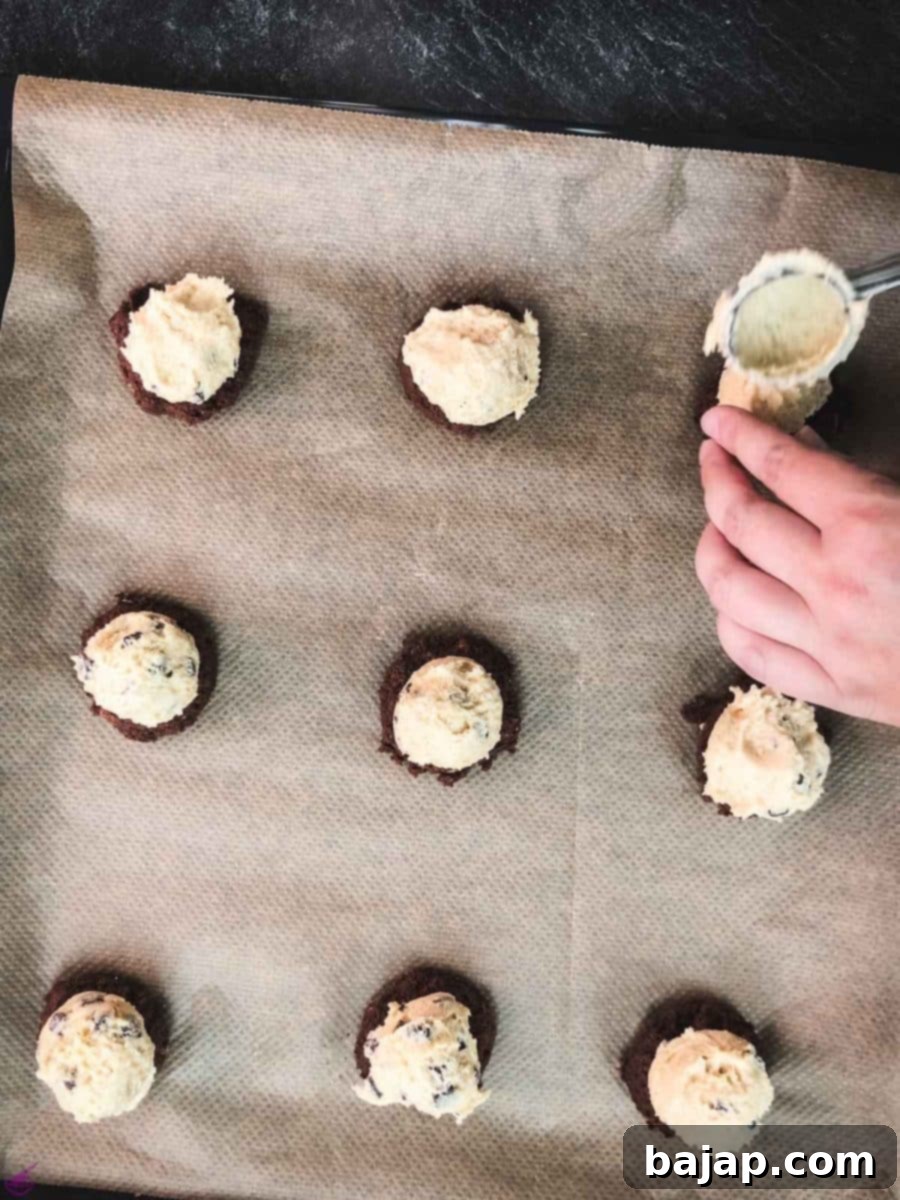 Scoop the vanilla cookie dough on top of the dark cookie dough with the marshmallow in the center.