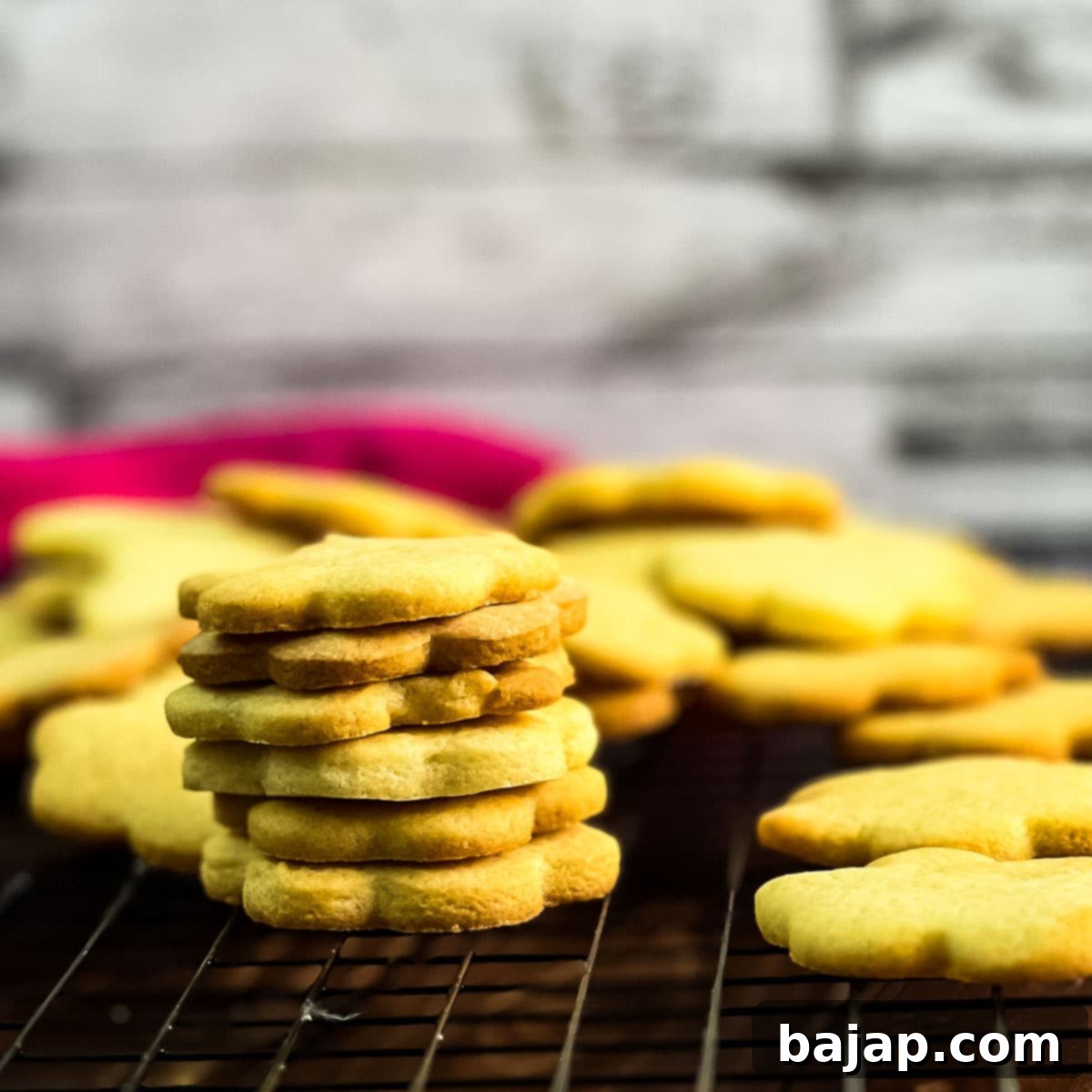 Gorgeous sugar cookies stacked beautifully on a cooling rack.