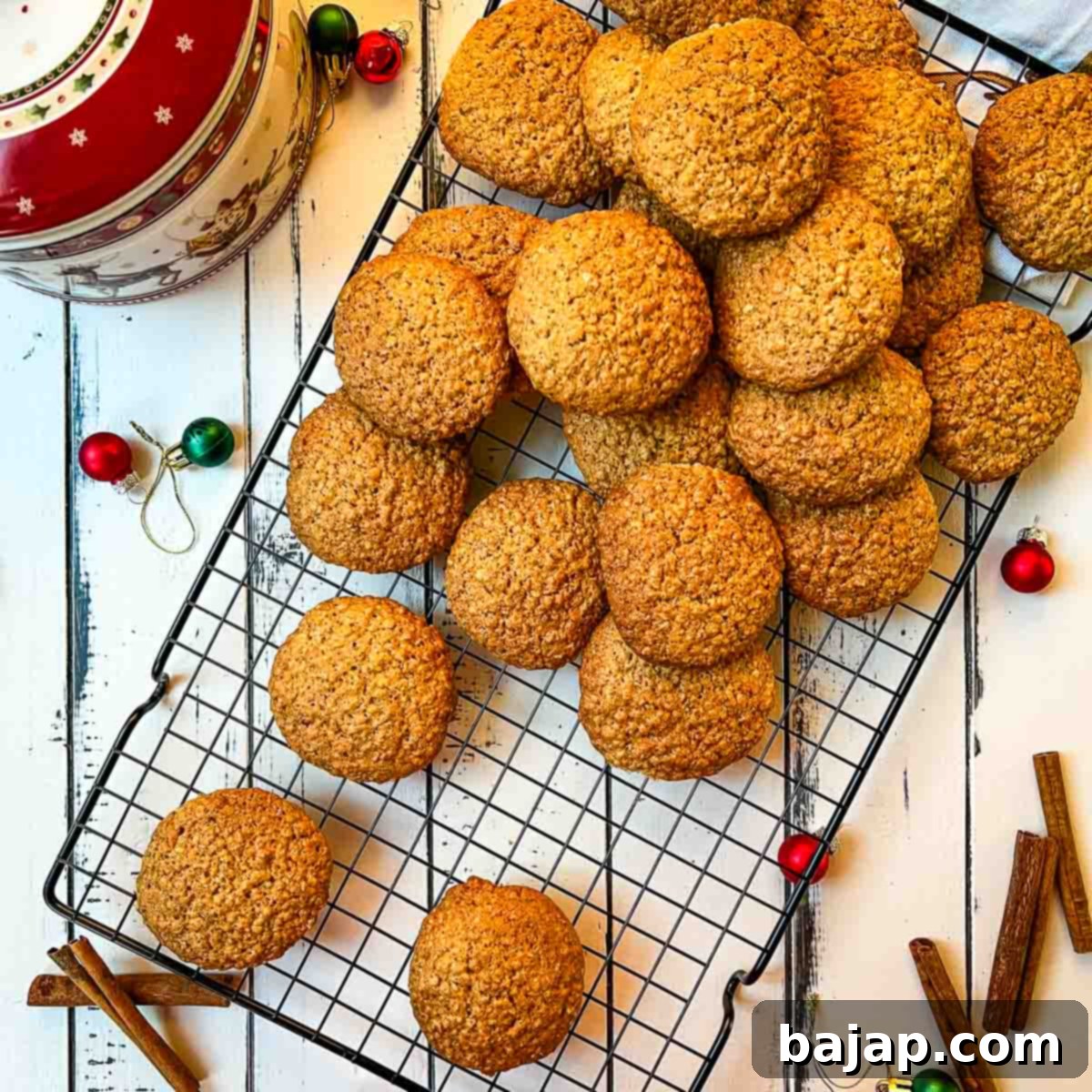 Oatmeal cinnamon cookies placed on cooling rack. Decorated with Christmas ornaments and cinnamon sticks.