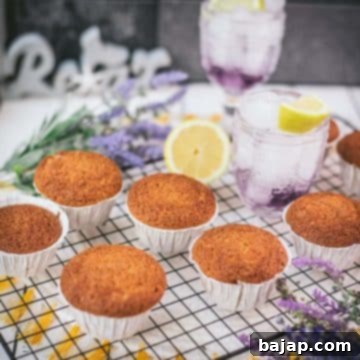 Delicious lavender lemon muffins, placed on cooling rack next to a lemon. These delightful muffins are butter-free, super fluffy, and burst with a subtle floral aroma of lavender combined with the zesty tang of lemon.