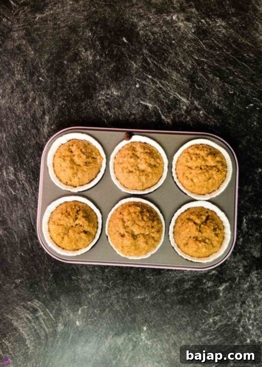 Freshly baked banana oatmeal muffins, golden and inviting, cooling on a rack right after baking, ready to be enjoyed.
