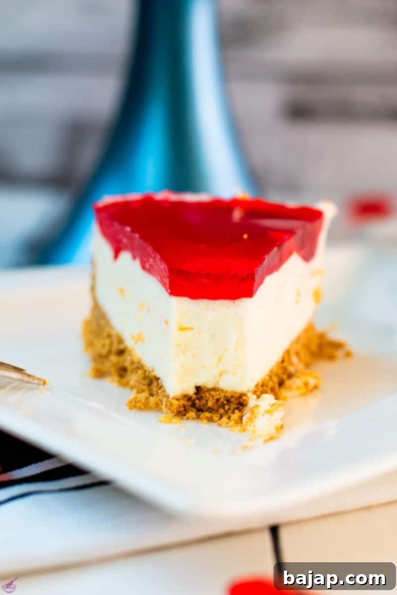 A slice of delicious Valentine's Raspberry Cheesecake placed on white plate next to a golden fork.