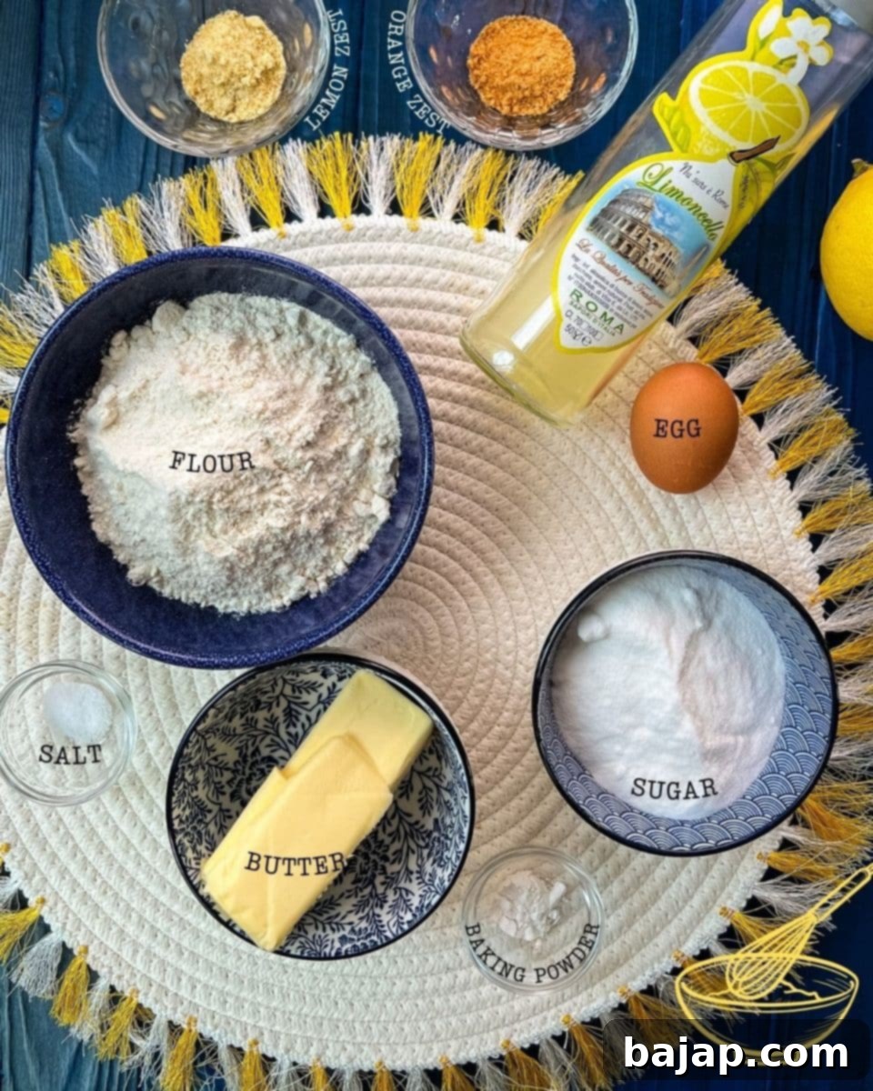 Ingredients for making lemon sugar cookies - flour, salt, butter, baking powder, sugar, an egg, lemon juice or limoncello, lemon and orange zest.