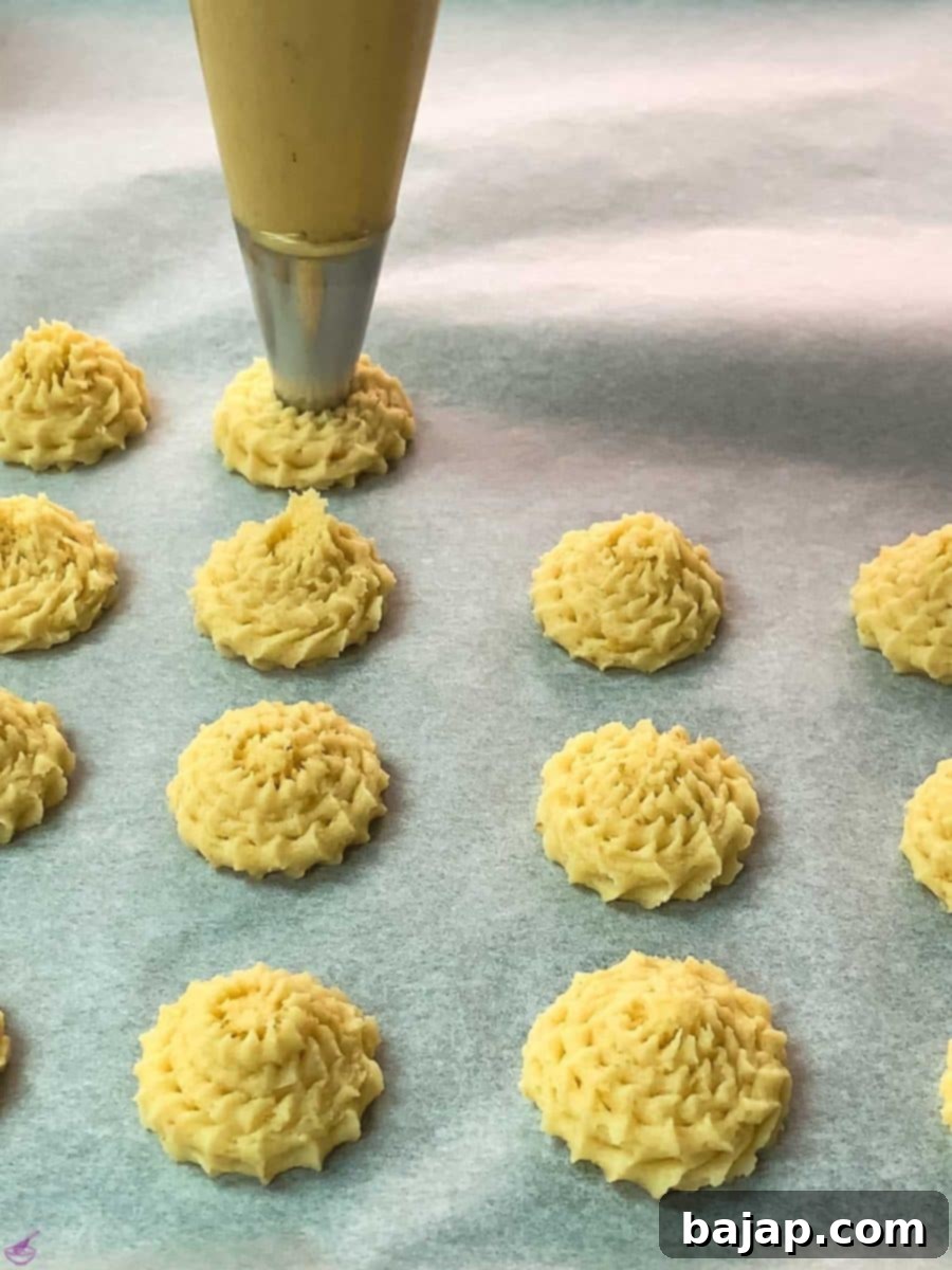 Pipe the lemon cookie dough on a baking sheet lined with parchment paper.