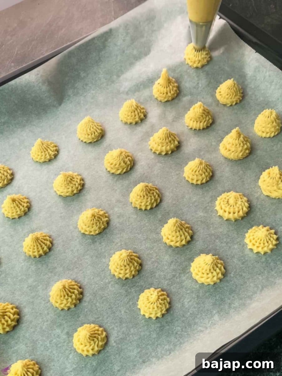 Pipe the lemon cookie dough on a baking sheet lined with parchment paper.