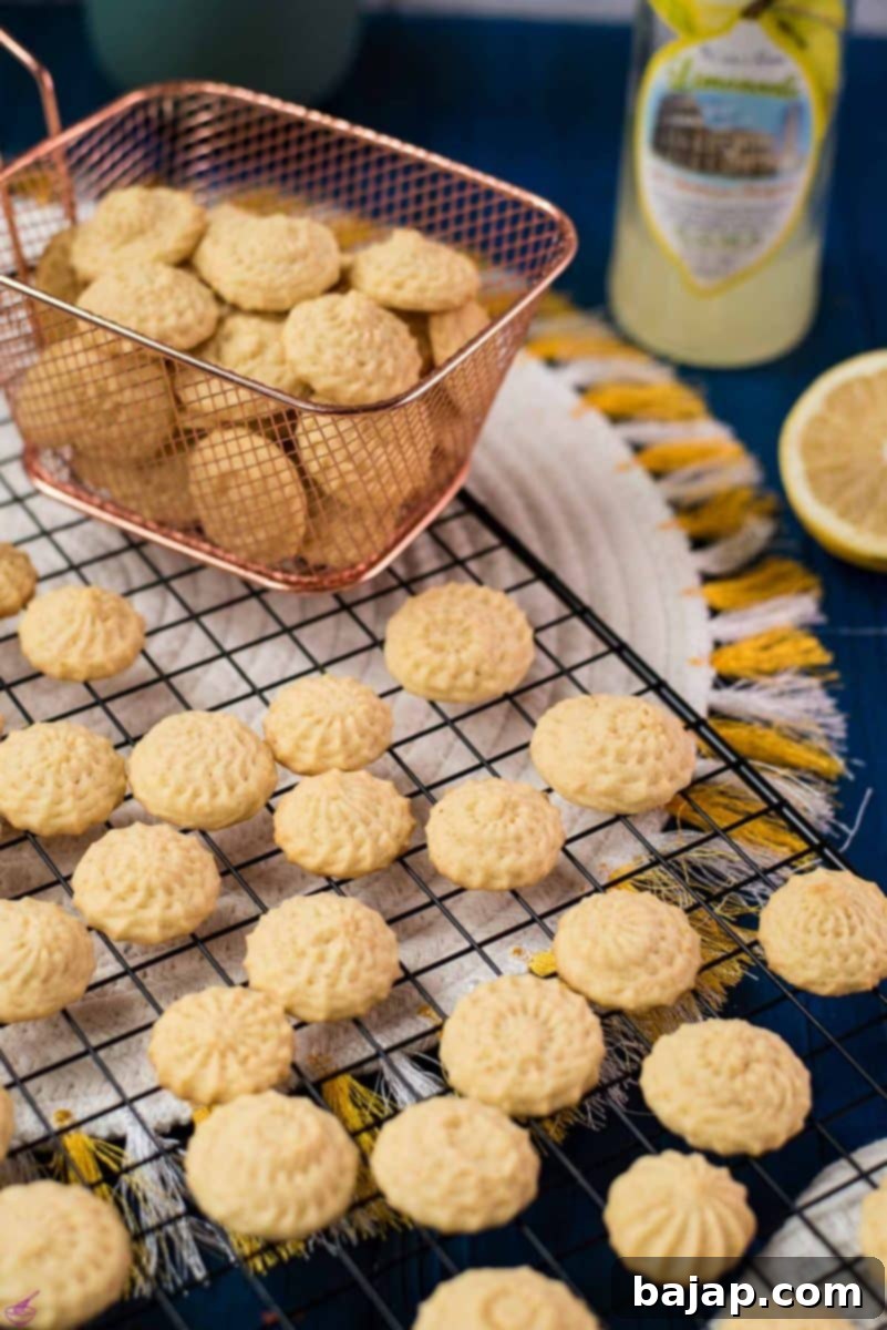 Gorgeous mini lemon sugar cookies placed on a cooling rack on a blue wooden ground.