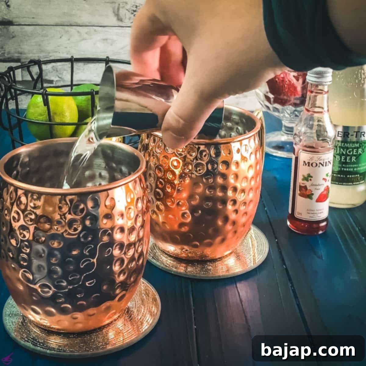 Pouring vanilla vodka into a copper mug.