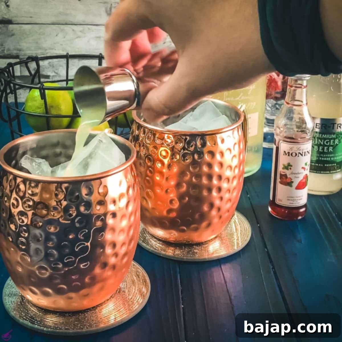 Adding fresh lime juice to the copper mug.