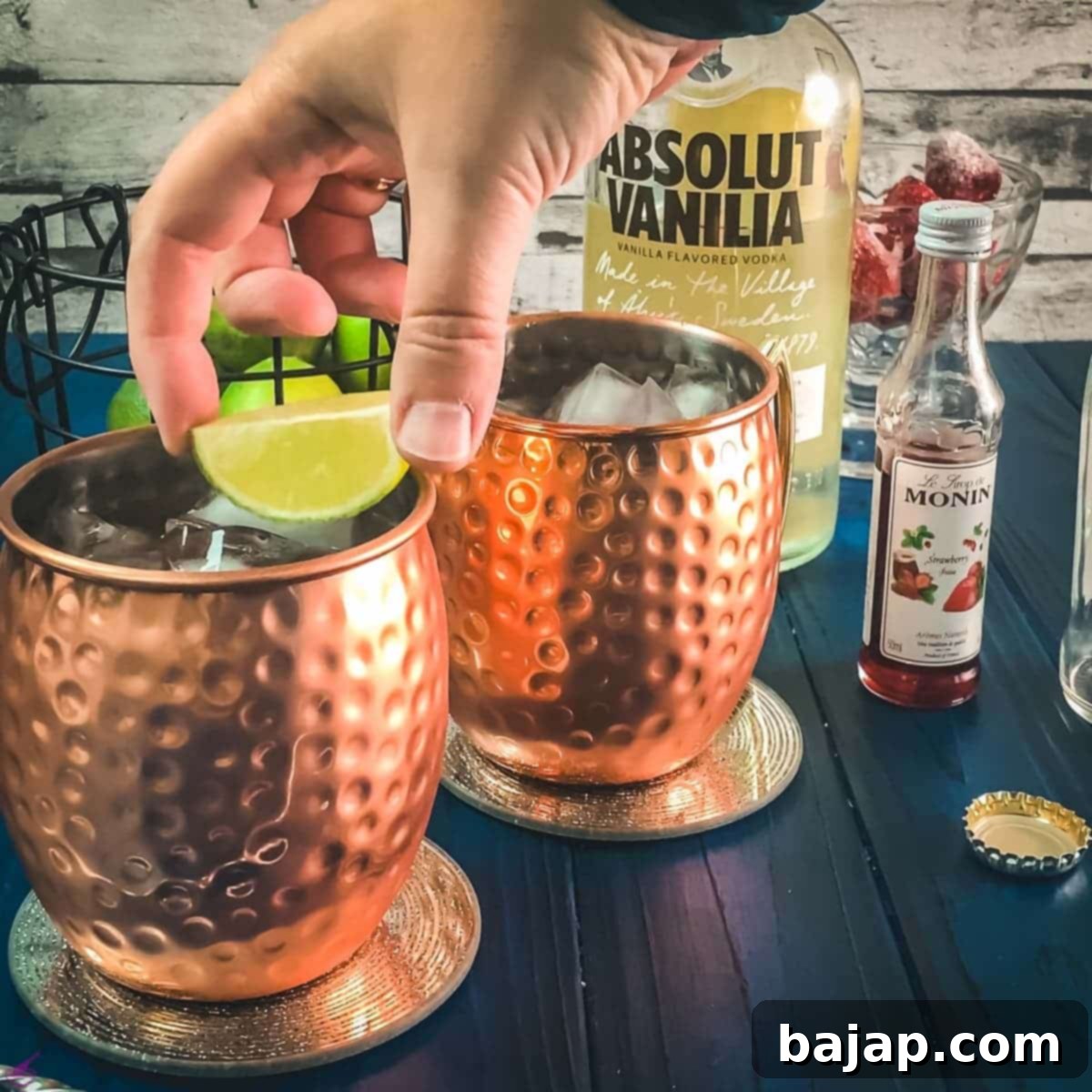 Garnishing the strawberry Moscow mule with a lime wedge.