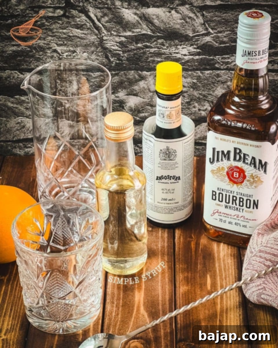 The three core ingredients for an Old Fashioned: a bottle of bourbon, Angostura bitters, and a jar of sugar syrup, neatly arranged.